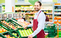 Homme remplissant desrayons de fruits et légumes